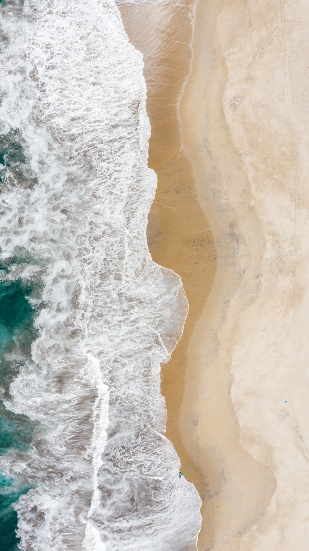 Veduta aerea delle onde dell'oceano che si infrangono sulla riva durante il giorno