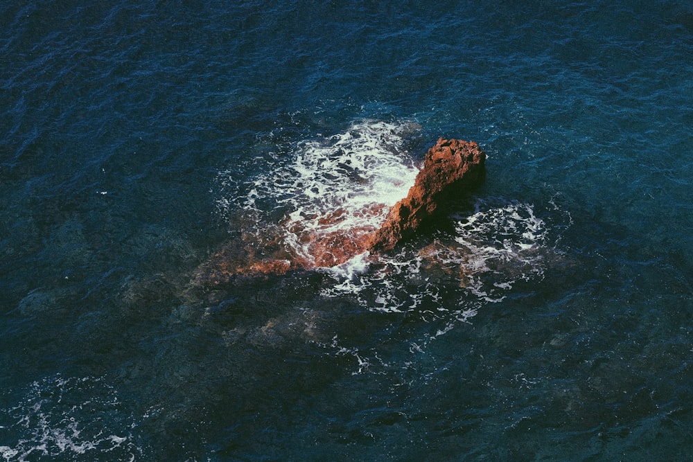 brown rock formation on blue sea during daytime