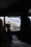 A panoramic view from inside an SUV capturing snow-capped mountains during an Uttarakhand tour