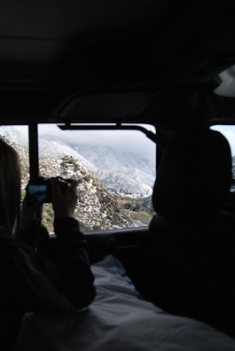A panoramic view from inside an SUV capturing snow-capped mountains during an Uttarakhand tour