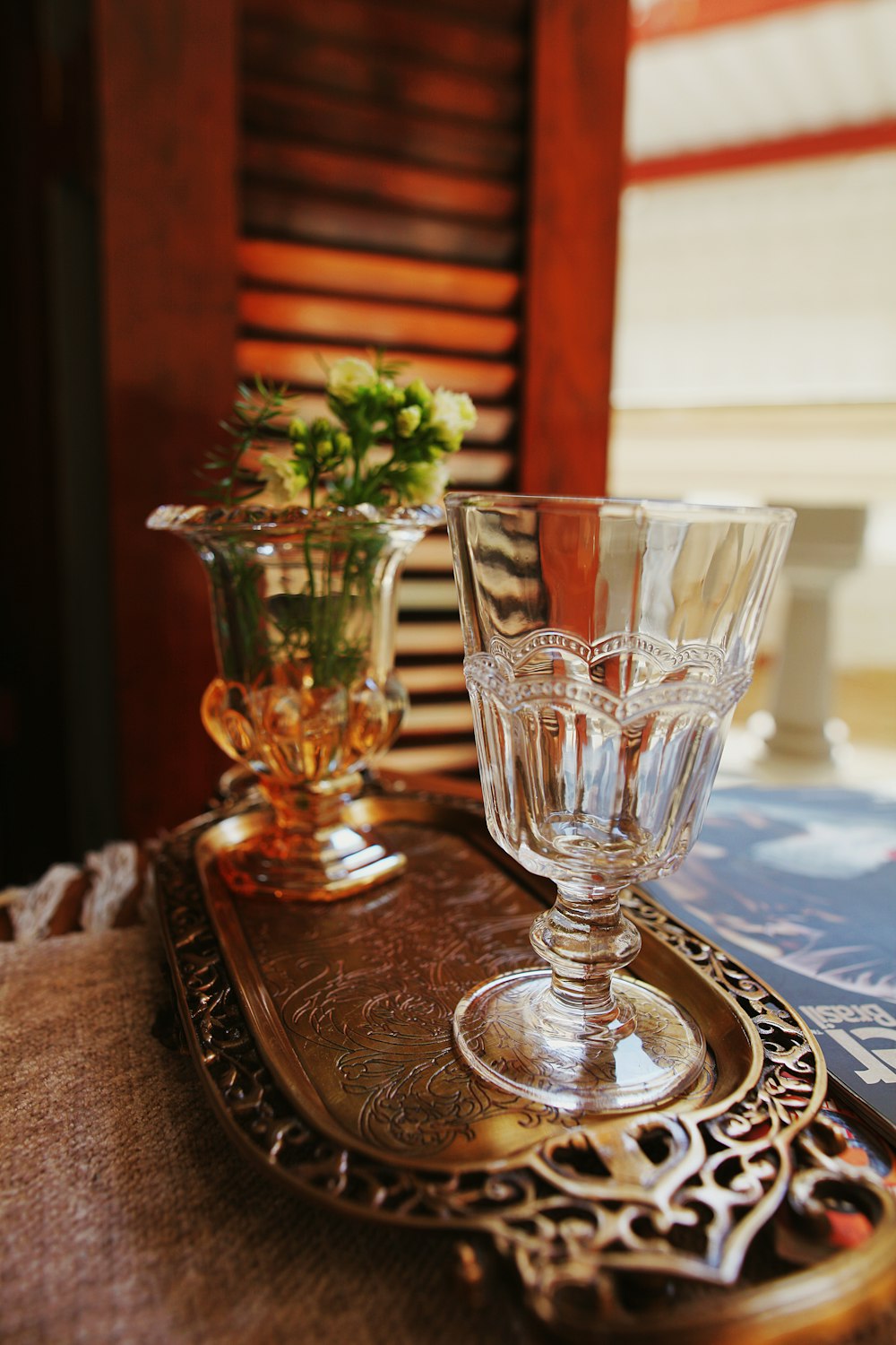 clear footed glass on blue and white floral table cloth