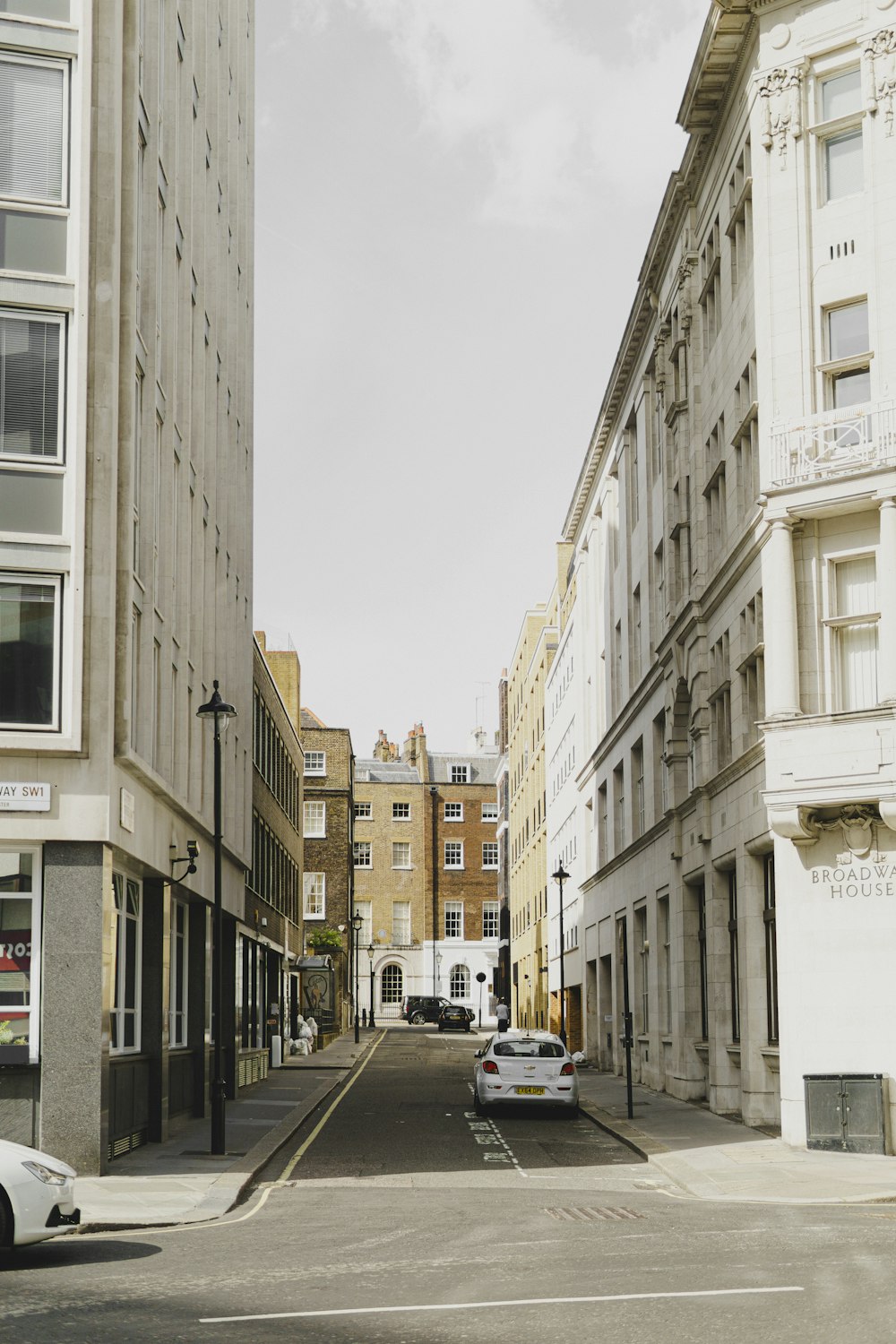 cars parked on side of the road in between buildings