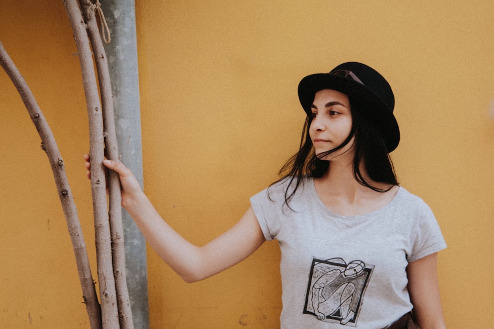 woman in white and black crew neck t-shirt wearing black hat