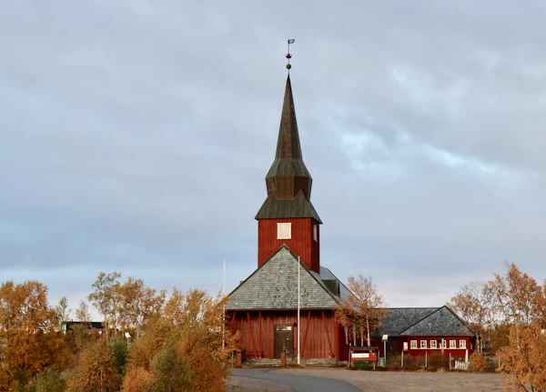 The red wooden church at Kautokeino on the Finnmark plateau, surrounded by autumn birch