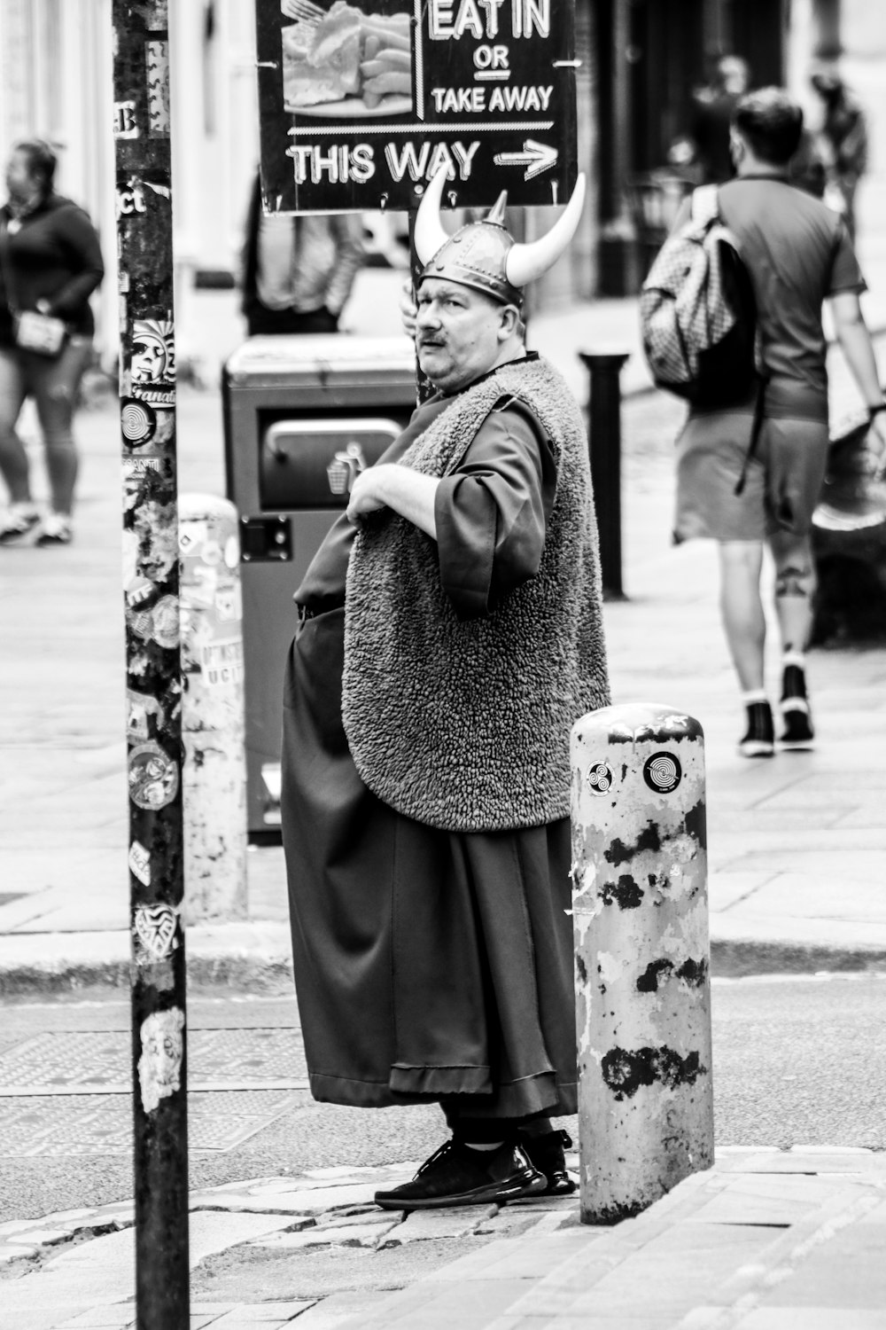 woman in black dress standing on sidewalk during daytime