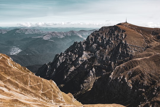 brown and gray mountains under white clouds during daytime in Bucegi Natural Park Romania