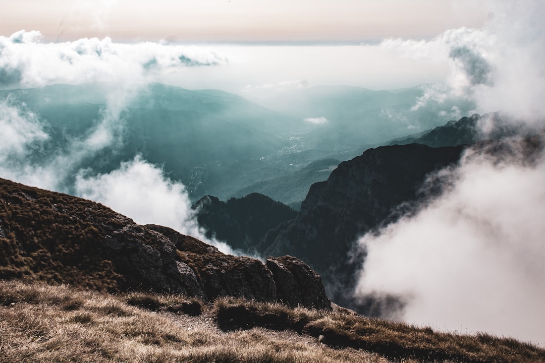 green grass covered mountain under white clouds during daytime