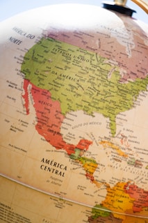 A close-up view of a globe focusing on North America and Central America. The map displays countries such as the United States, Mexico, and regions in Central America with country names and major cities labeled. The colors distinguish different countries and regions with shades of green, red, and yellow.