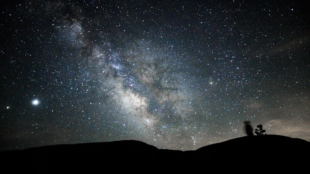 silhouette of mountain under starry night