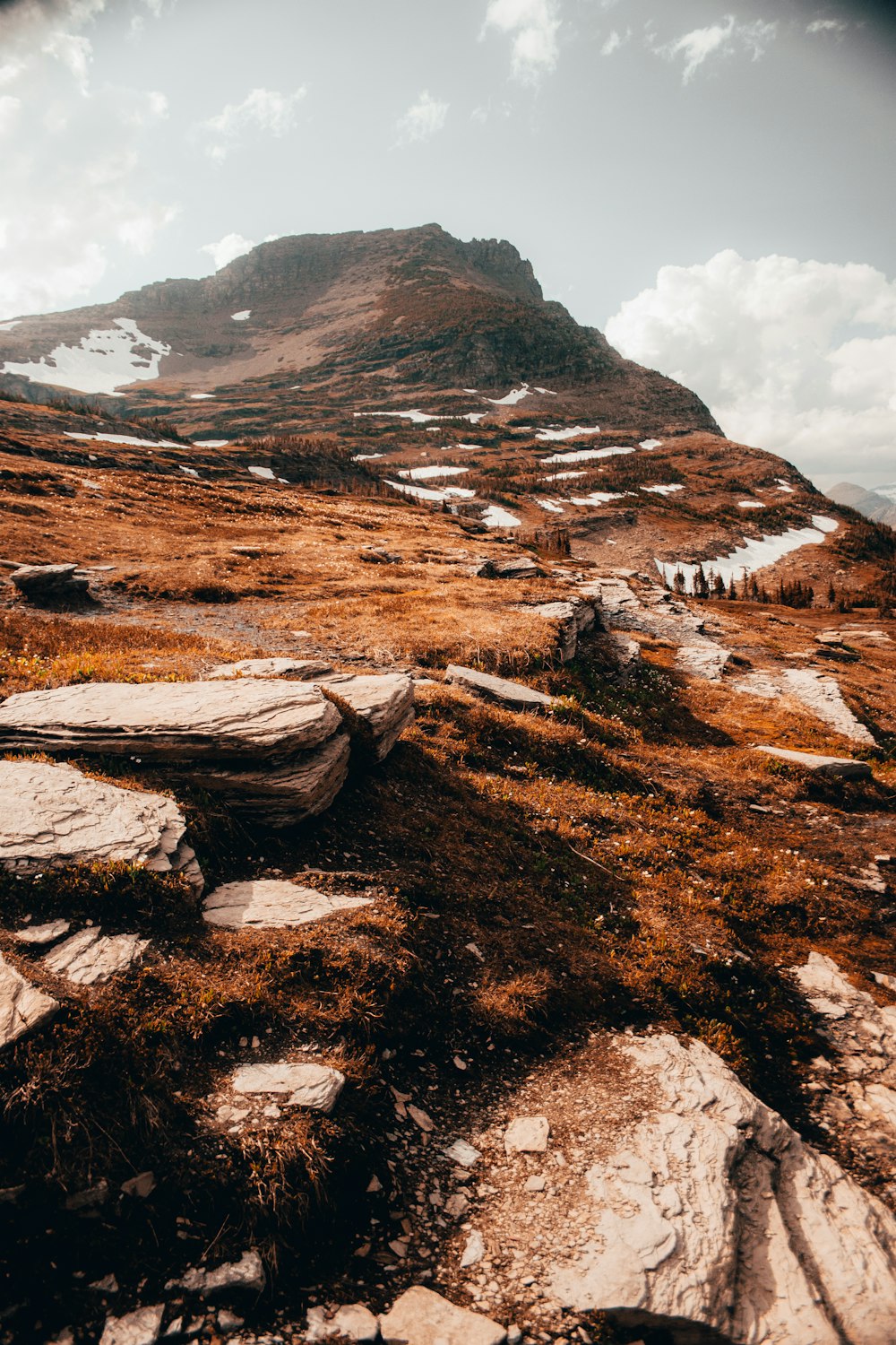 brown and gray rock formation under white clouds during daytime