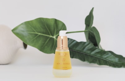 yellow plastic bottle beside green leaf