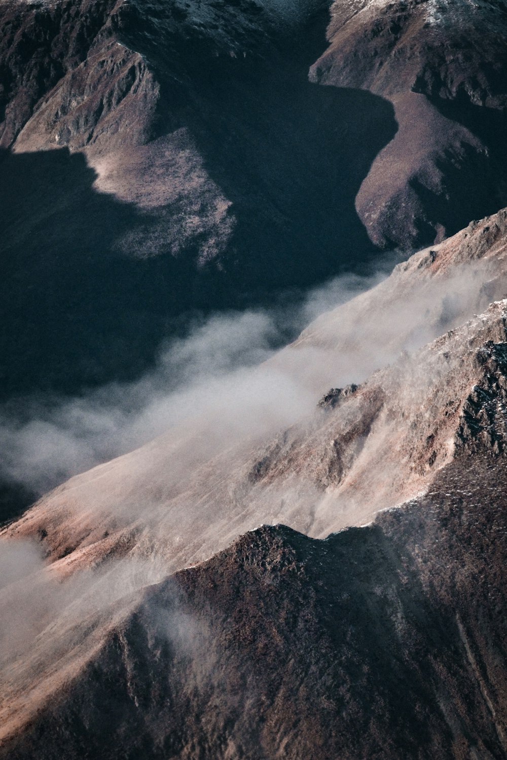 montagne noire et blanche sous des nuages blancs