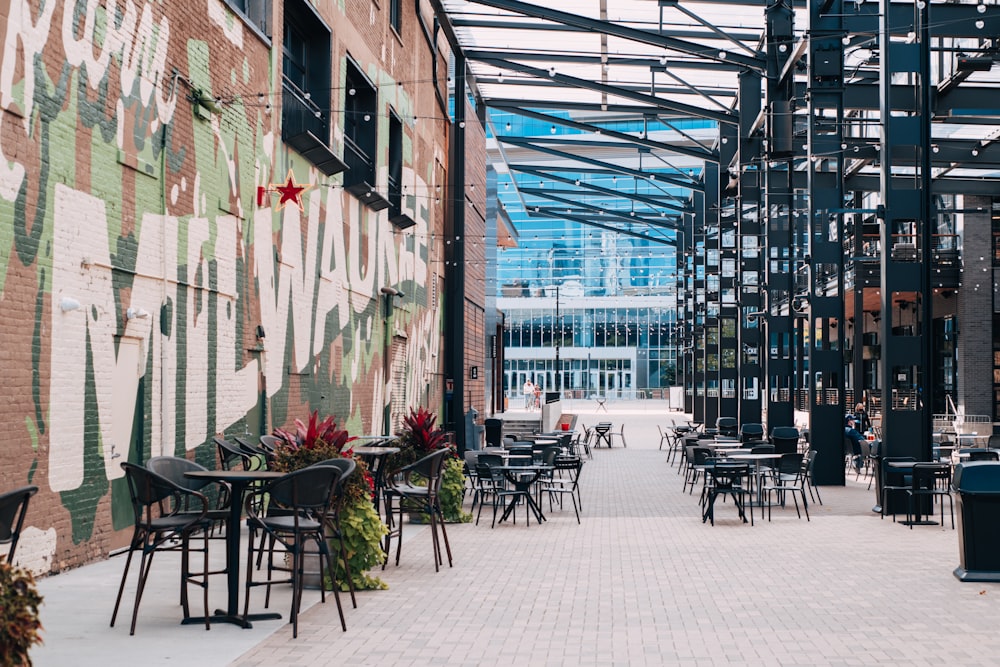 black metal chairs and tables outside building during daytime