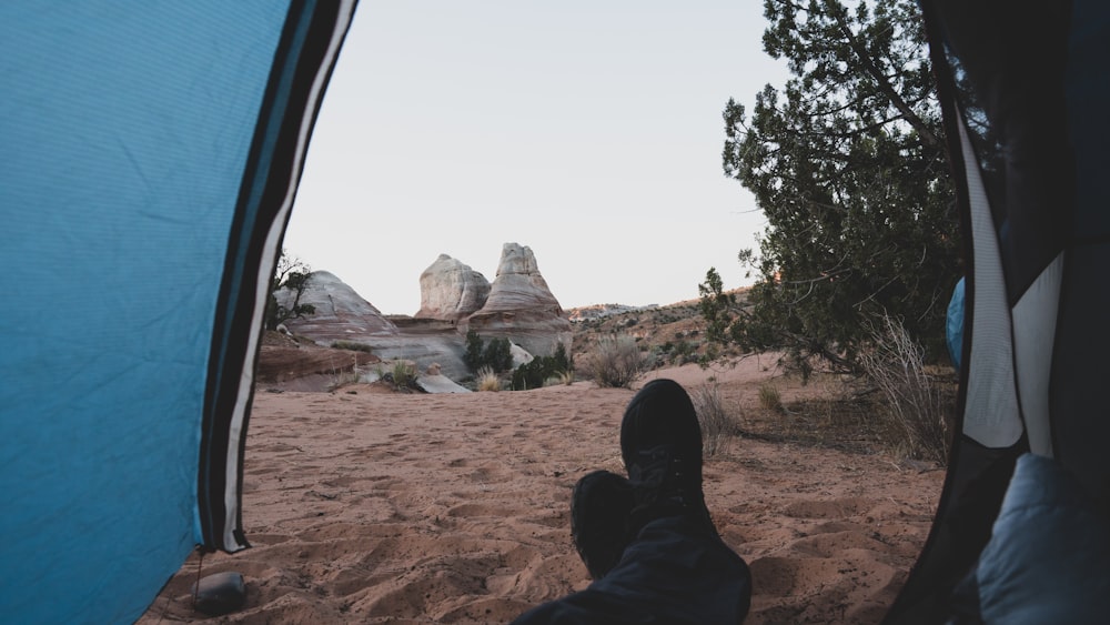 person in black pants and black shoes sitting on car