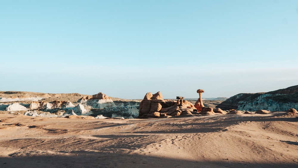 man in brown jacket sitting on brown rock formation during daytime