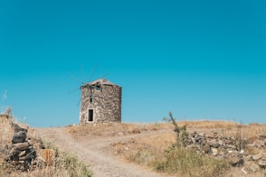 brown concrete building on brown field under blue sky during daytime