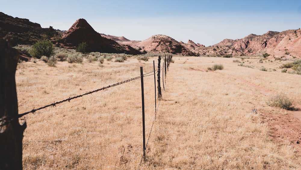 brown wooden fence on brown grass field during daytime