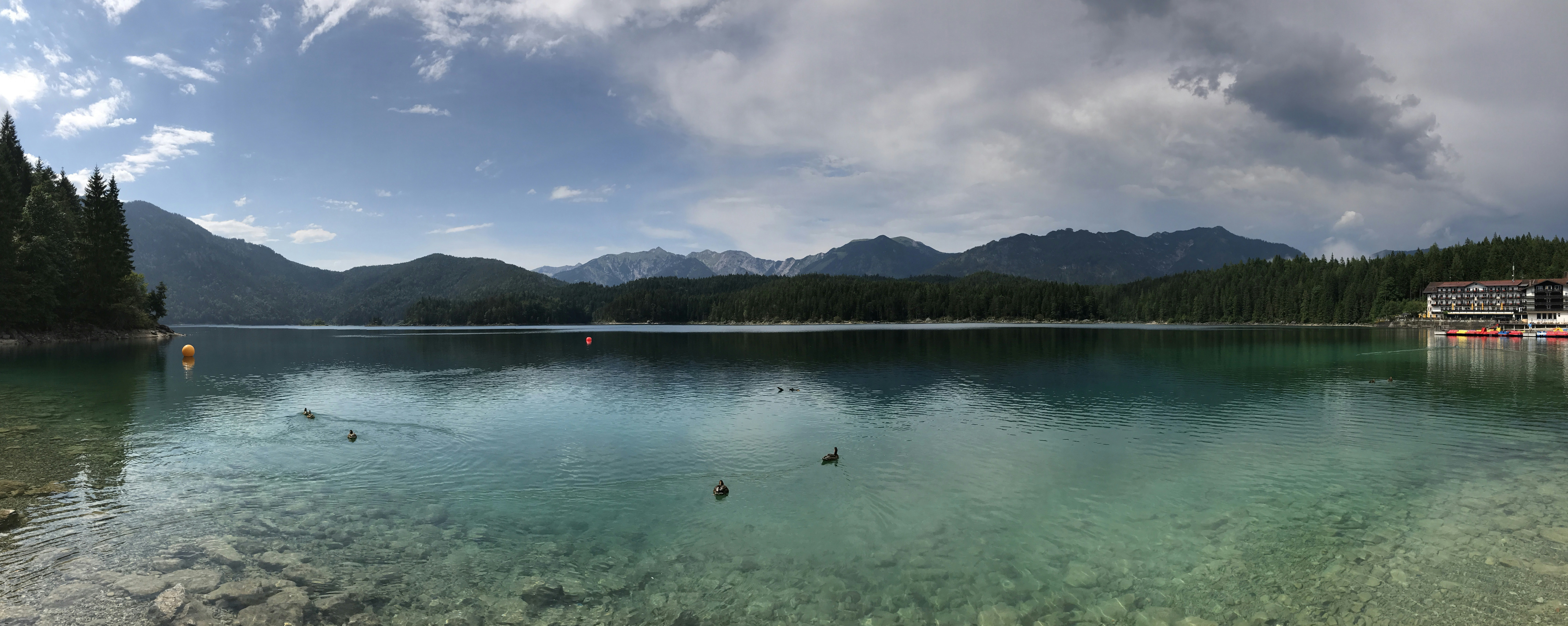 body of water near mountain under blue sky during daytime