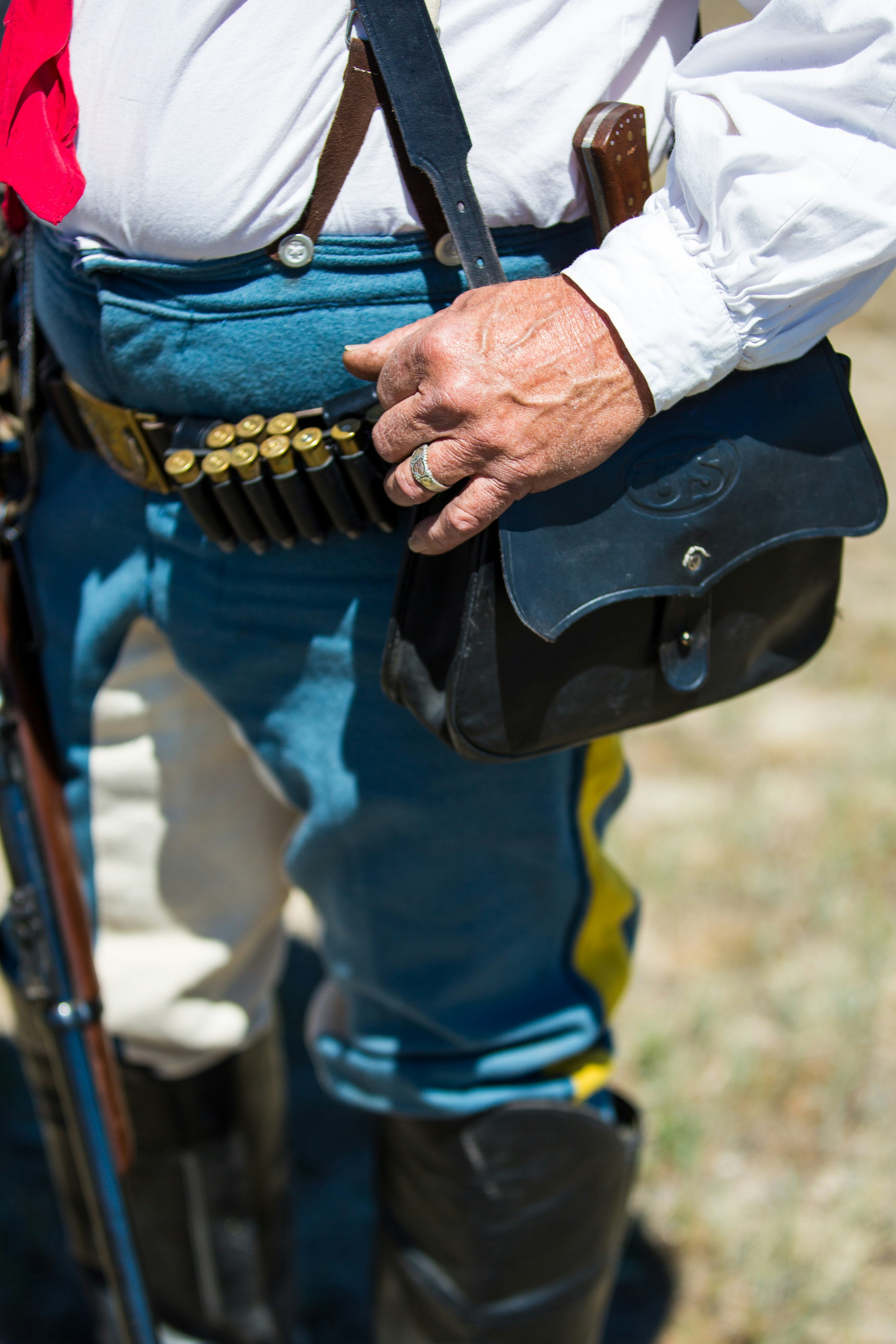person in blue and yellow jacket holding black and brown leather bag