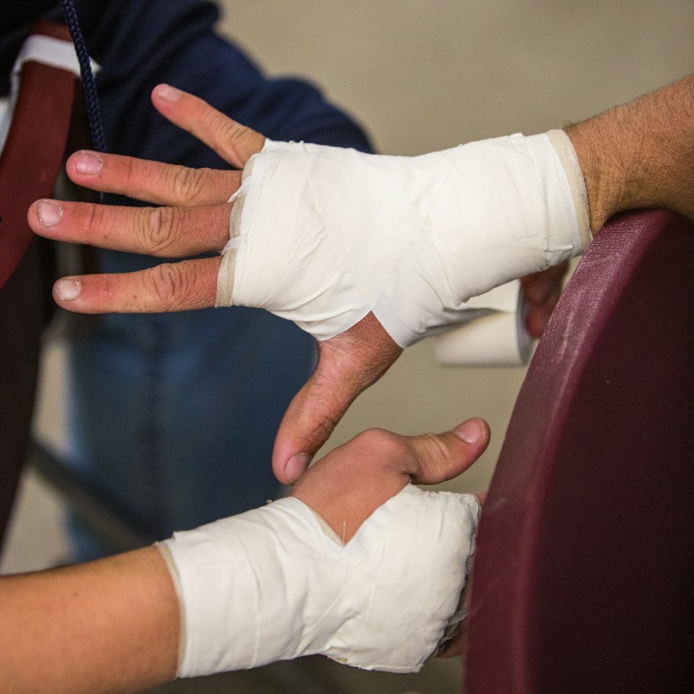 person in white gloves holding persons hand