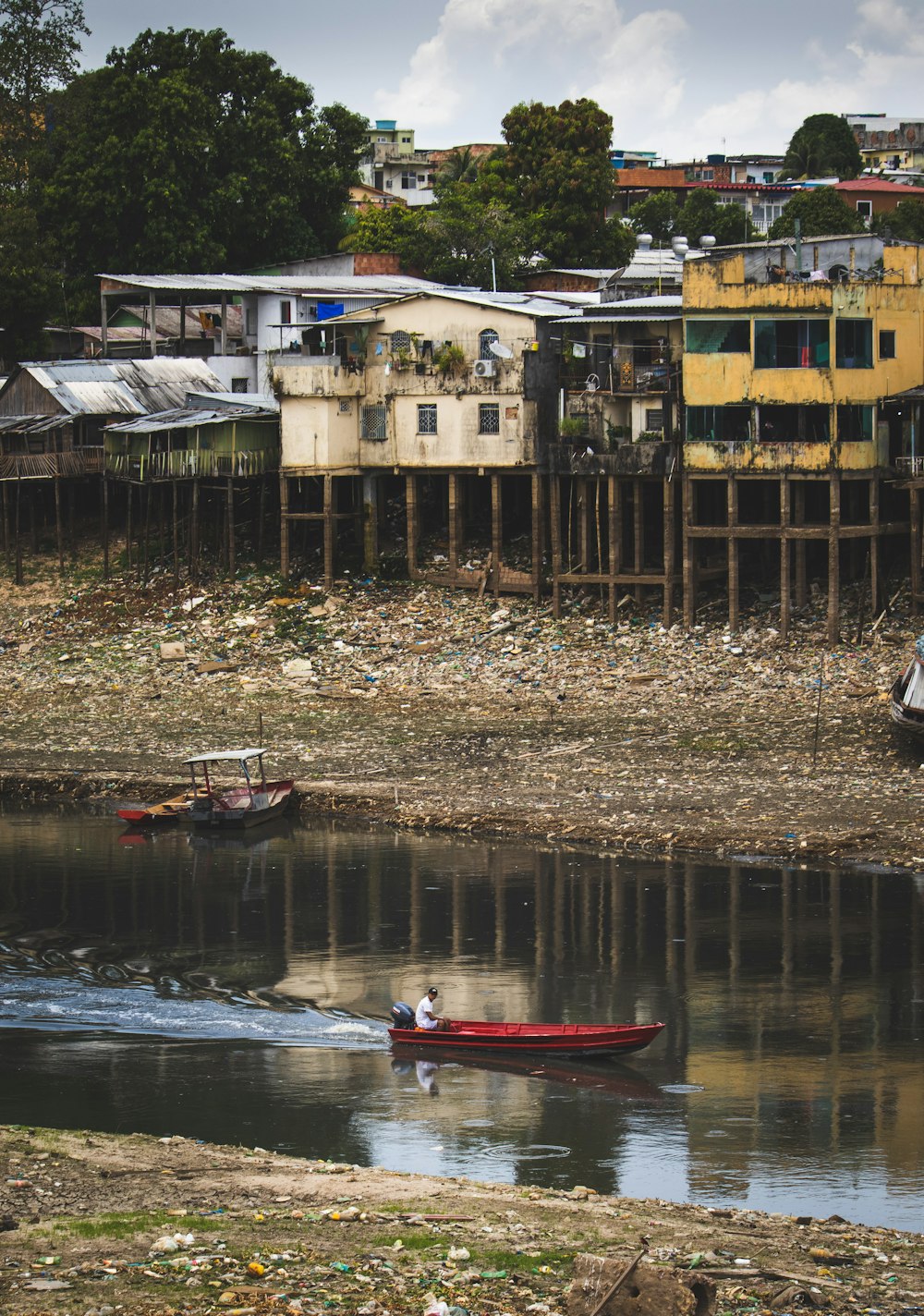 red boat on river near brown wooden bridge during daytime