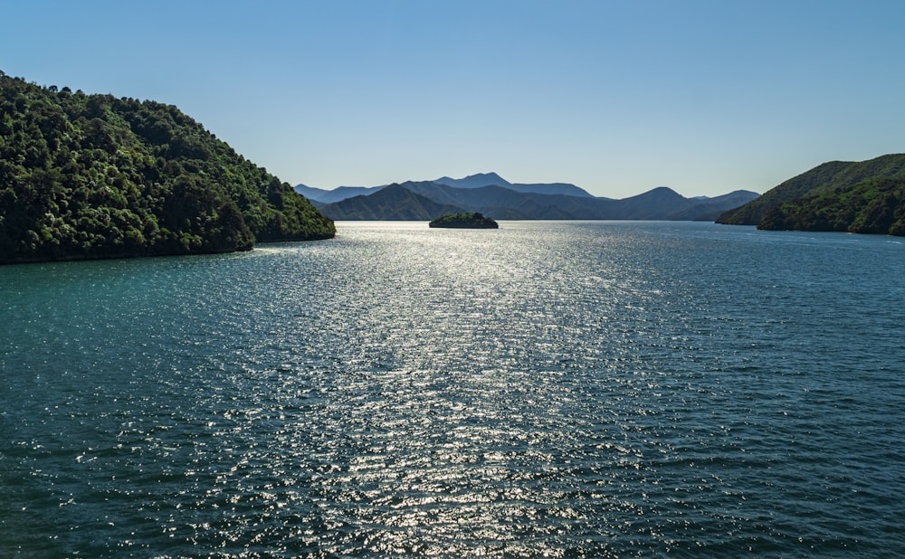 body of water near mountain during daytime