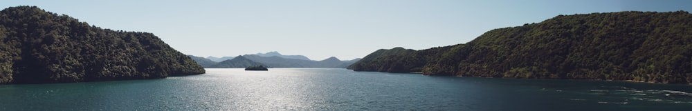 body of water near mountain during daytime