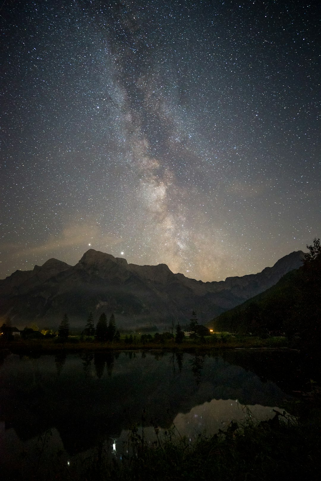 body of water near mountain under starry night