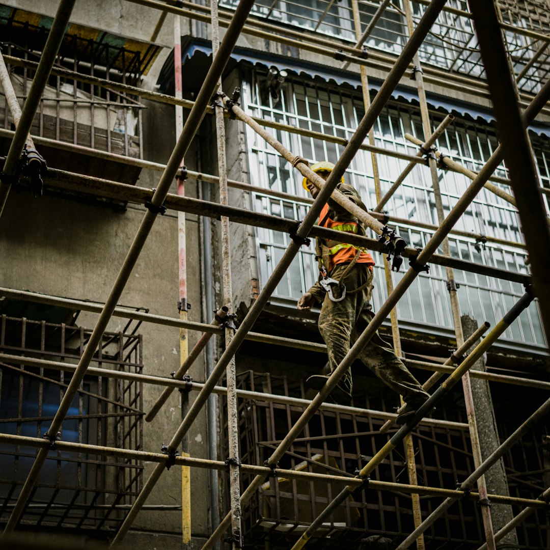man in brown jacket and black pants climbing on ladder