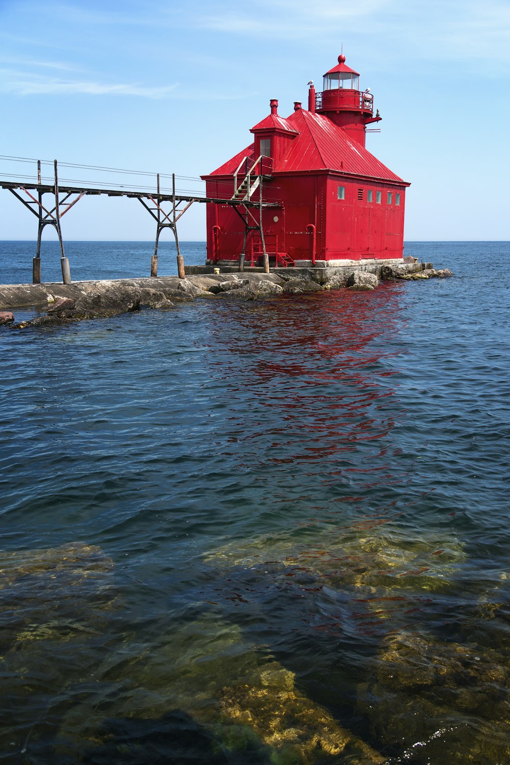 Casa de madera roja y blanca junto al cuerpo de agua durante el día