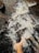 A bare foot is immersed in flowing water with bubbles and foam, surrounded by natural rocky surfaces.
