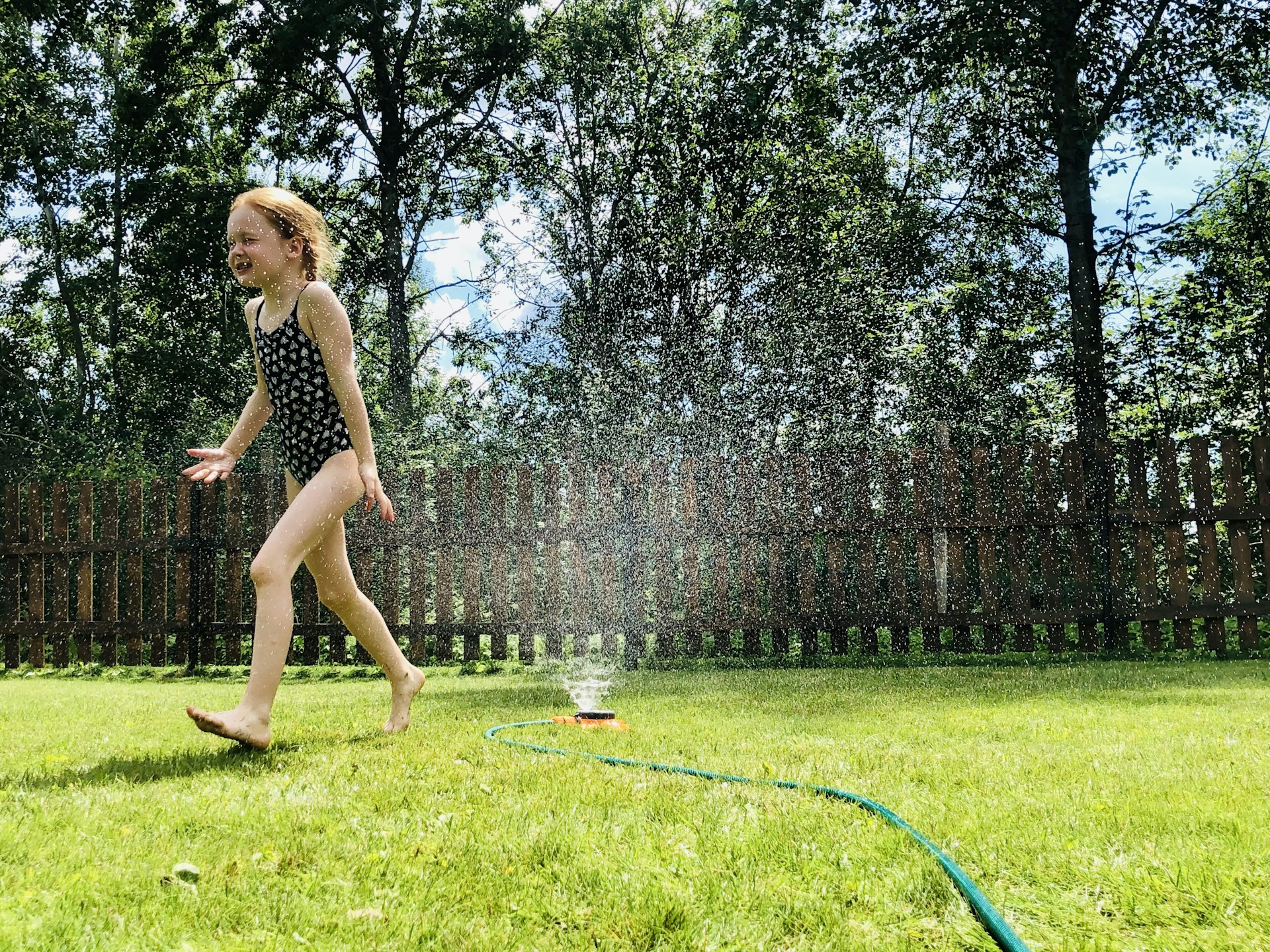woman in black tank top and black shorts standing on green grass field during daytime