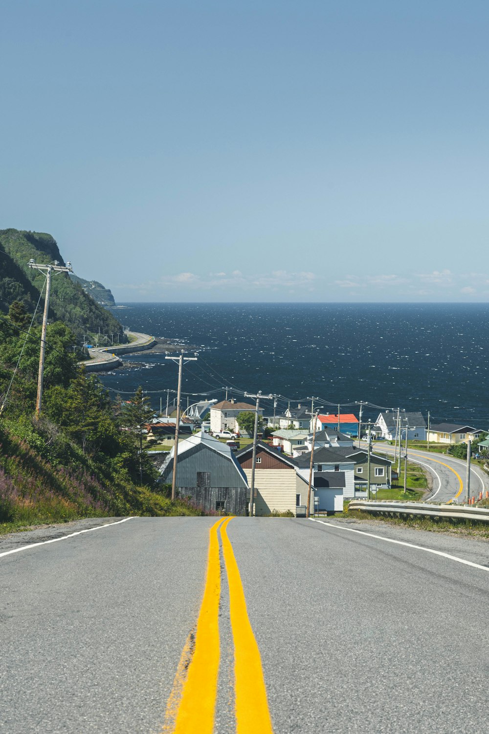 gray concrete road near houses and mountain during daytime