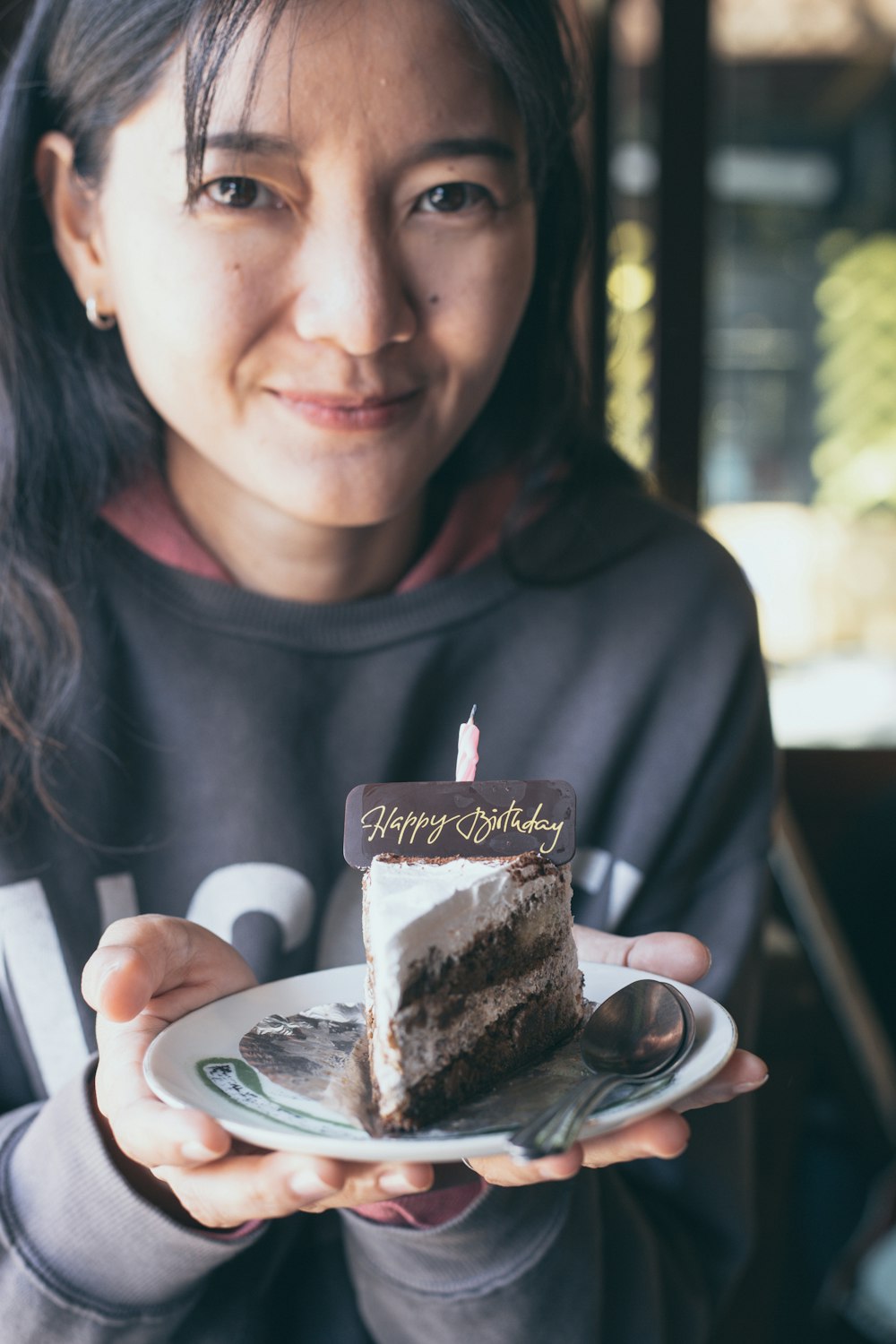 woman in black crew neck shirt holding chocolate cake