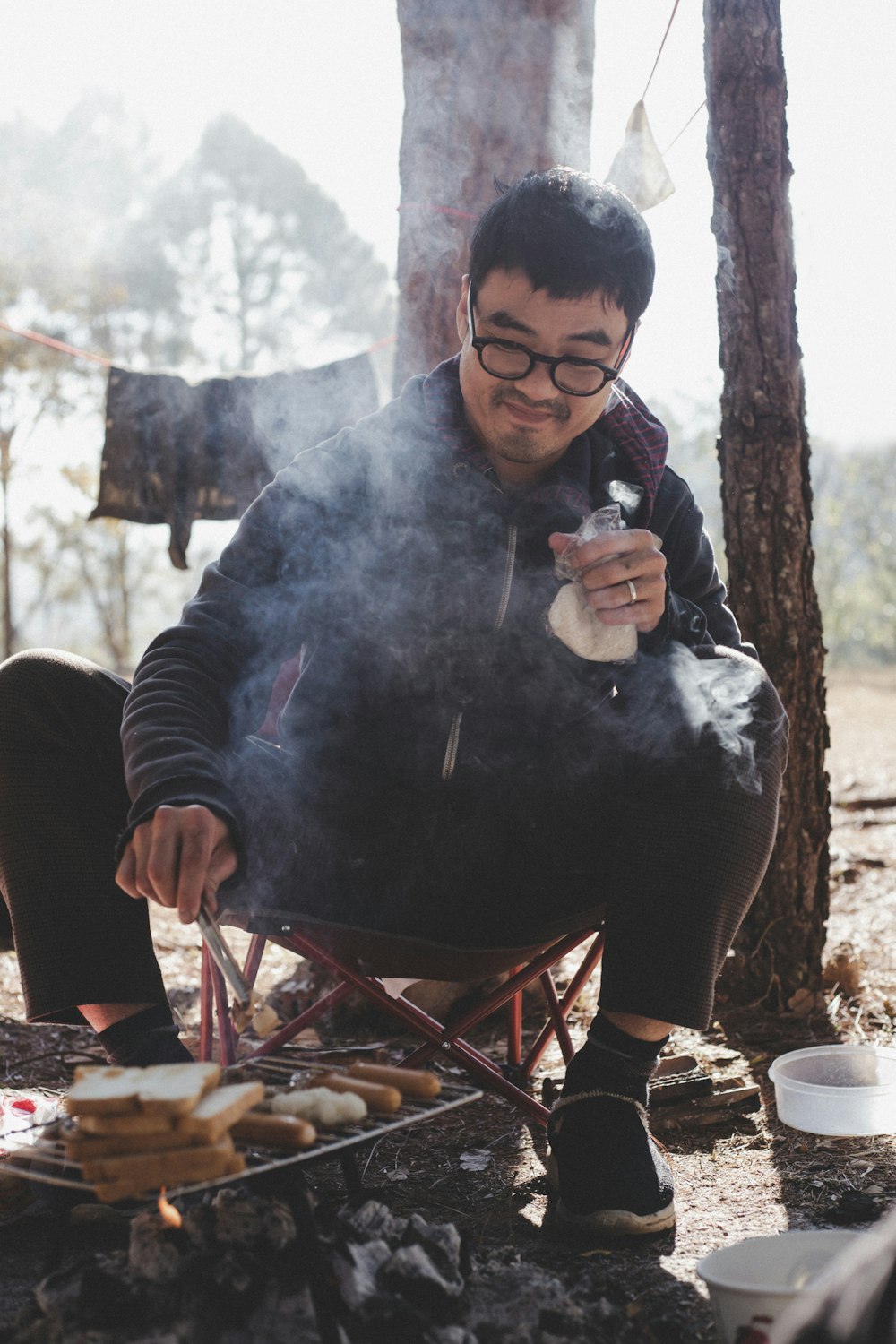 man in black jacket holding white ceramic mug