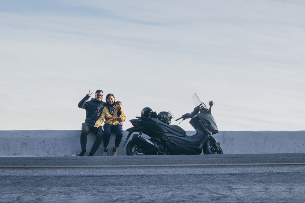 黒いスポーツバイクに座る男女3人