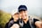 man in black shirt beside woman in white fitted cap
