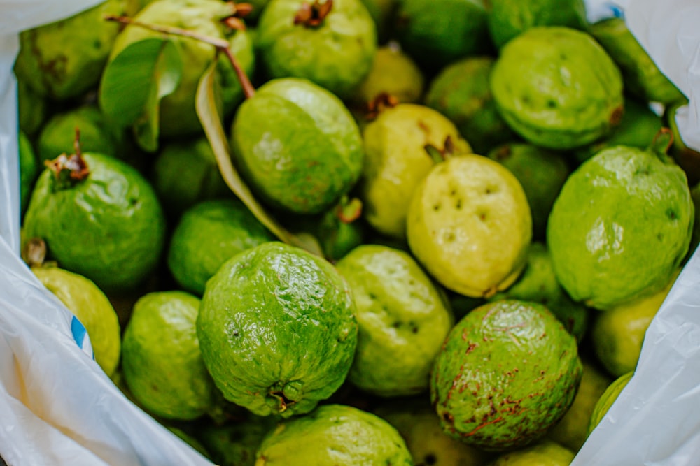 green fruits on white ceramic bowl