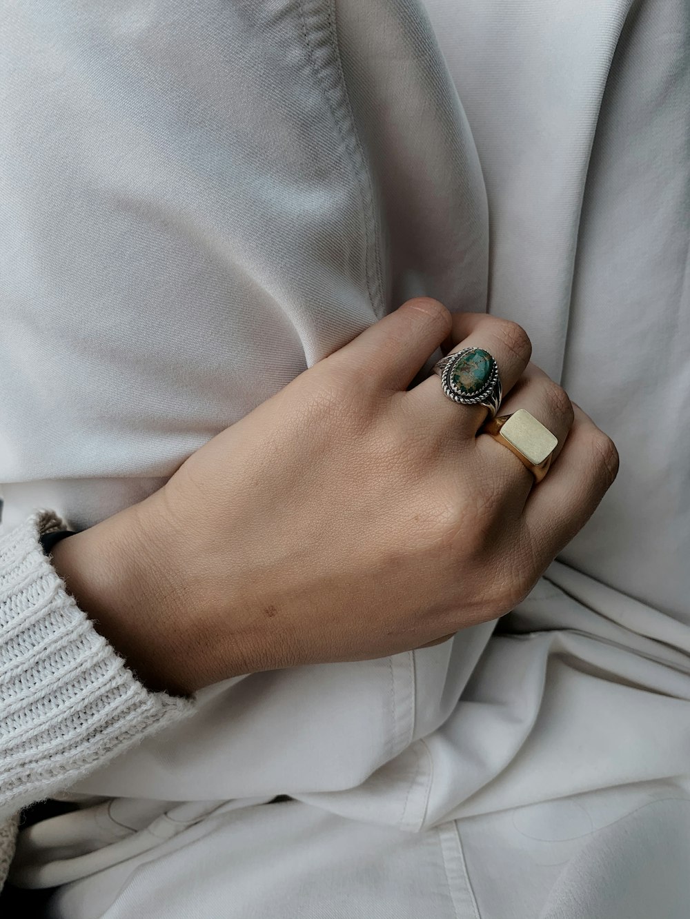 person wearing silver and green ring