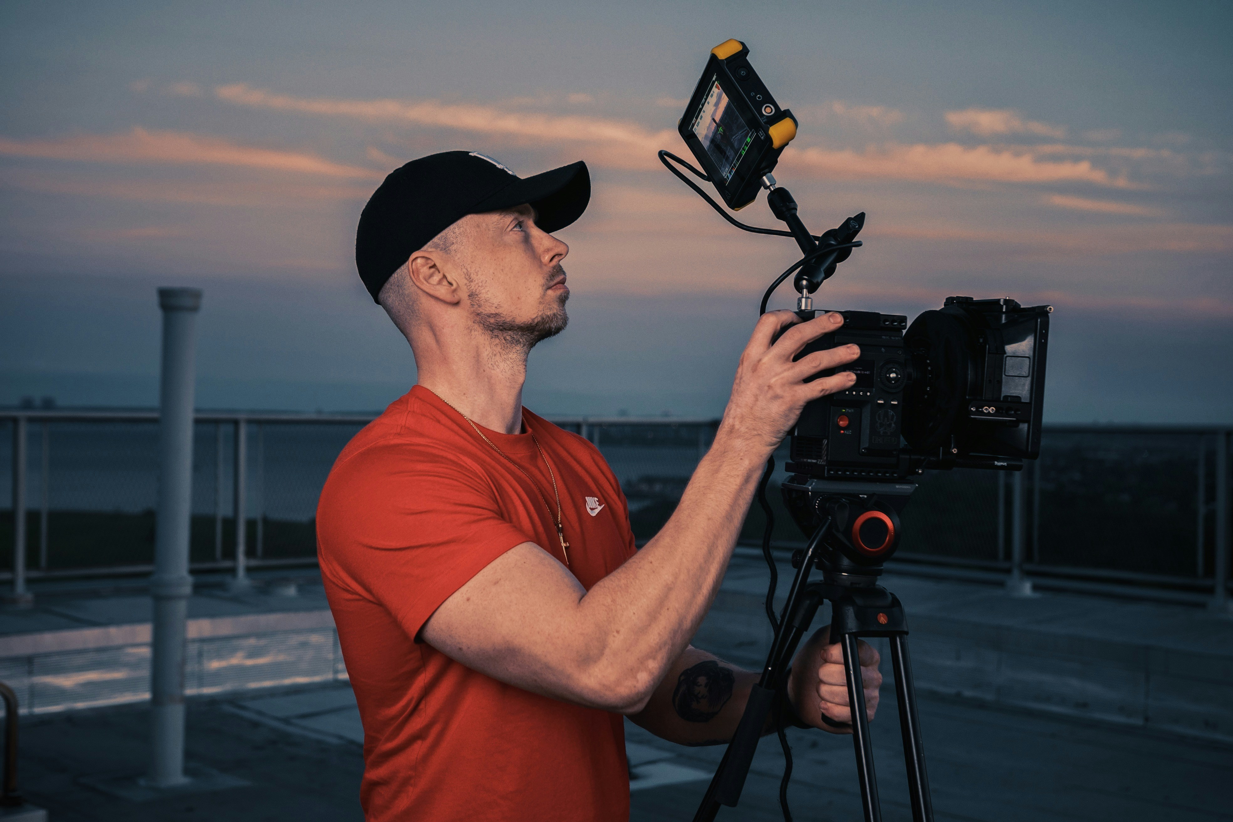 man in red crew neck t-shirt holding black camera