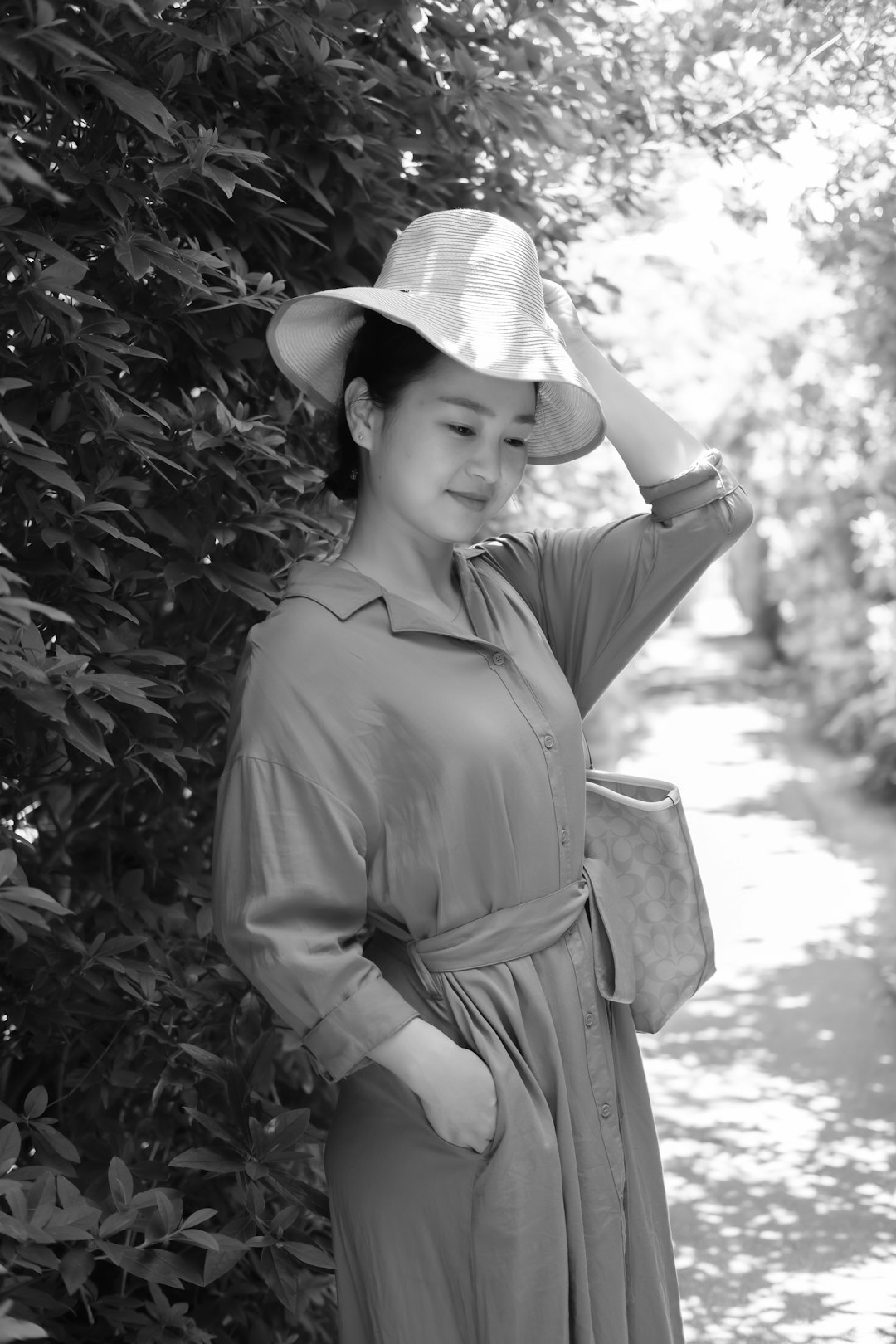 grayscale photo of woman wearing hat and coat