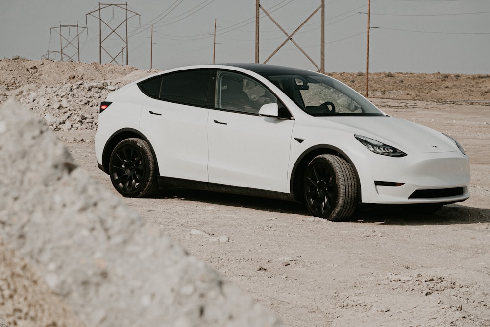 white sedan parked on white concrete floor