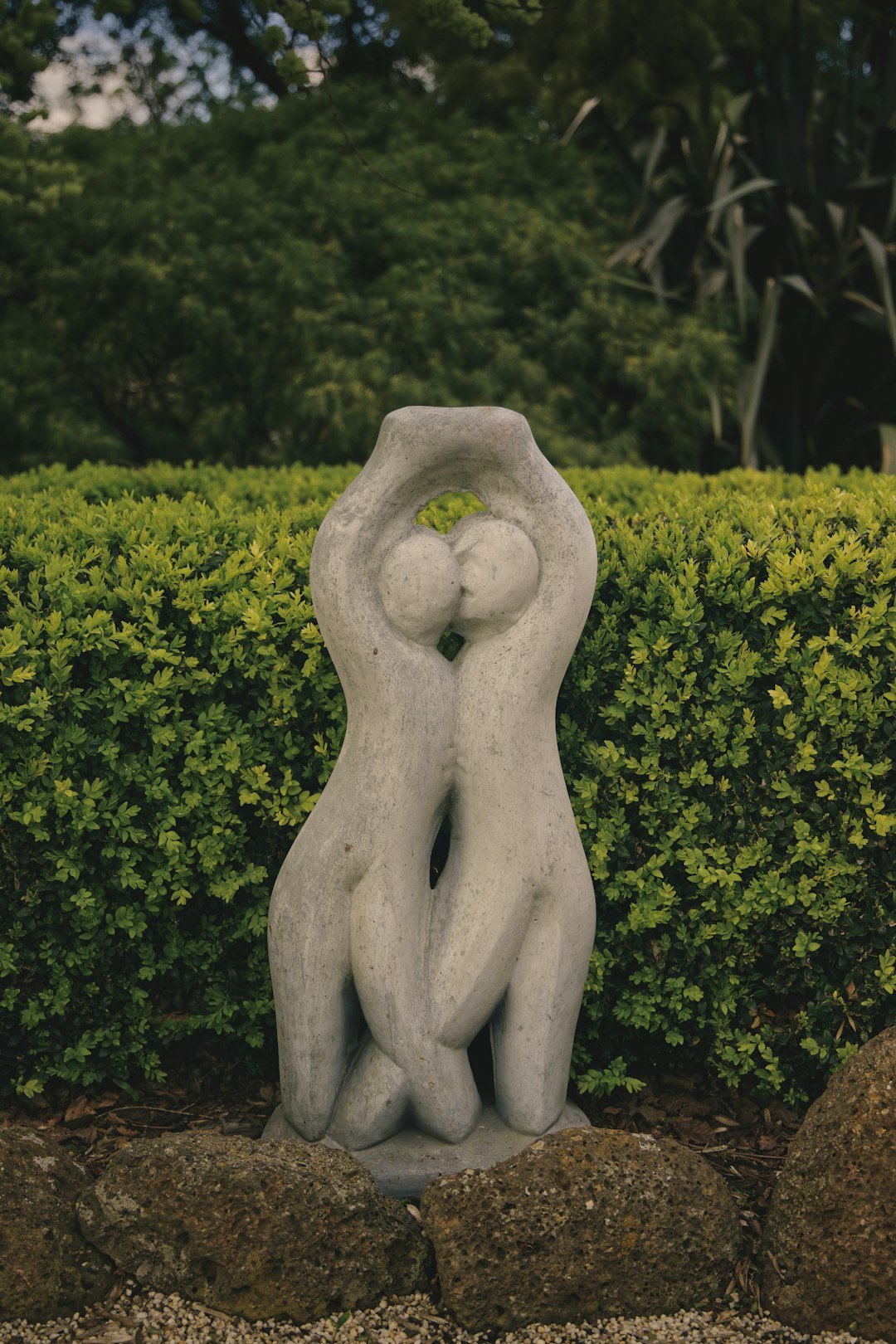 white concrete statue near green trees during daytime