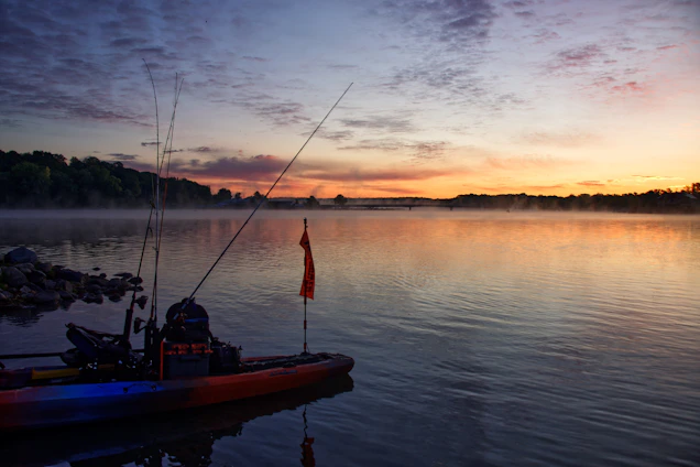 A serene sunrise over the turquoise waters of Mauritius with fishing rods and tackle laid out on a wooden dock.