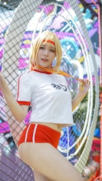 A person in a sporty outfit is posing in front of a colorful, graffiti-covered wall. They are wearing a white and red athletic attire with shorts, and they have a medal around their neck. The background is vibrant and filled with abstract designs and shapes.