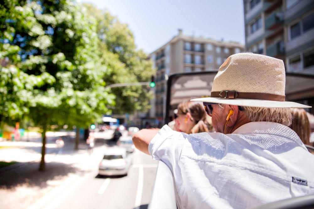 uomo in camicia bianca e cappello fedora marrone