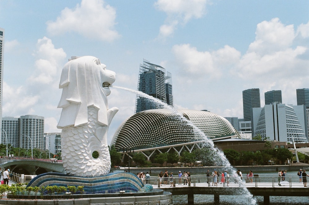 Estatua de hormigón blanco cerca de los edificios de la ciudad durante el día