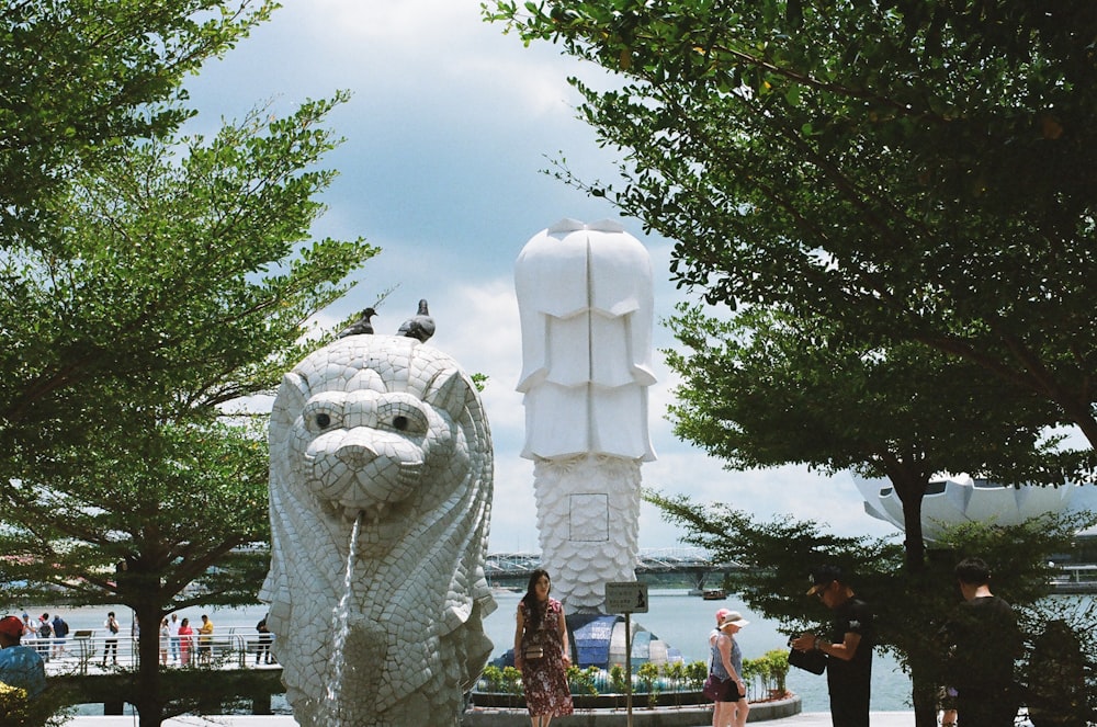 people standing near white animal statue during daytime