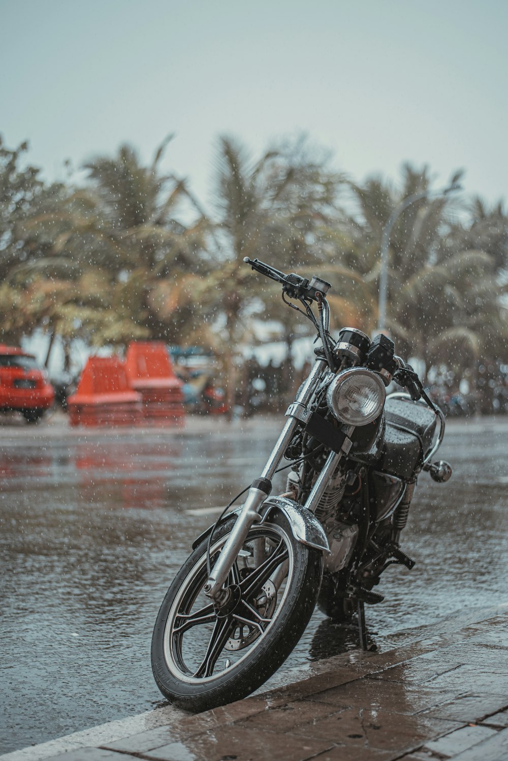 black motorcycle parked beside body of water during daytime