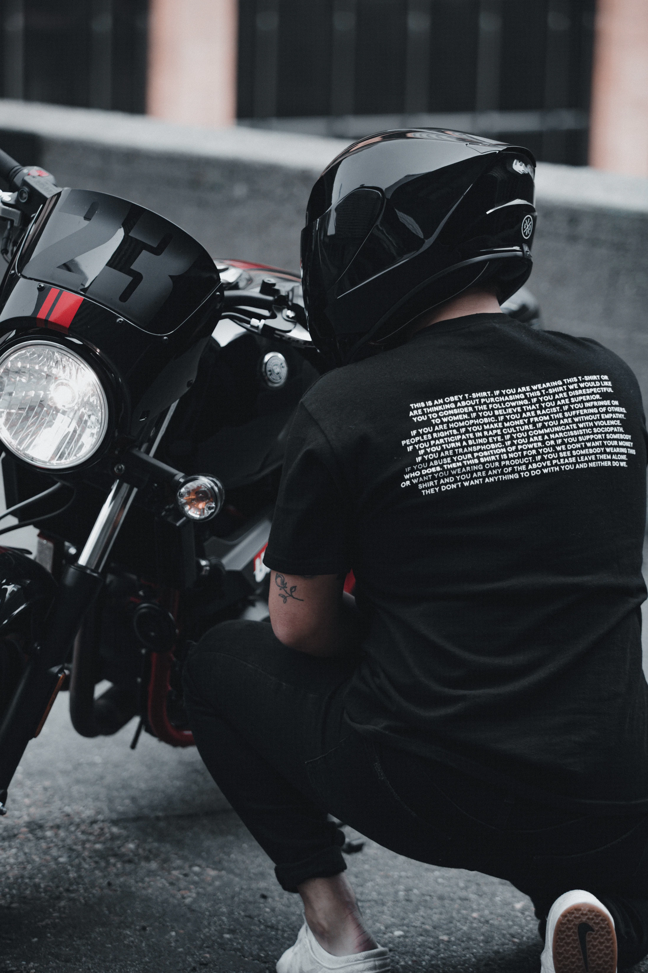 Motorcycle rider in black helmet and dark gear with a performance motorcycle